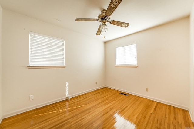 empty room with ceiling fan and light hardwood / wood-style flooring