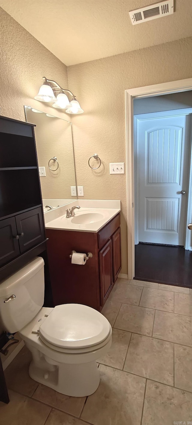 bathroom with toilet, tile patterned floors, and vanity