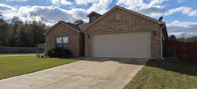 view of property featuring central AC unit, a front lawn, and a garage