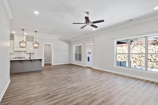 unfurnished living room with ornamental molding, ceiling fan, and hardwood / wood-style floors