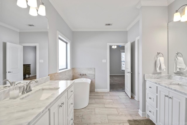 bathroom featuring ornamental molding, vanity, and a bathing tub