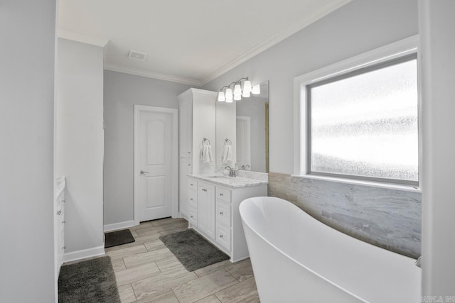 bathroom with a washtub, crown molding, and vanity