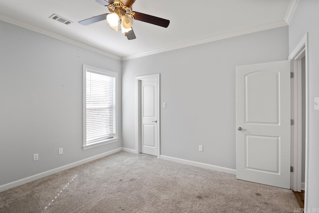 carpeted spare room featuring ceiling fan and crown molding