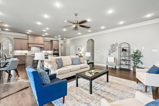 living room with light wood-type flooring, ceiling fan, and crown molding