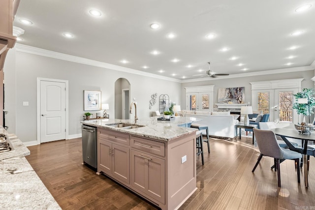 kitchen featuring sink, ceiling fan, light hardwood / wood-style flooring, an island with sink, and light stone countertops