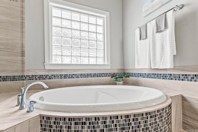 bathroom with tiled tub and plenty of natural light