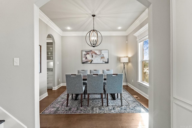 dining space featuring an inviting chandelier, crown molding, and dark hardwood / wood-style flooring