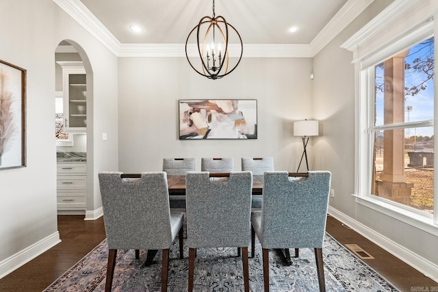 dining space featuring a notable chandelier, dark hardwood / wood-style flooring, and ornamental molding