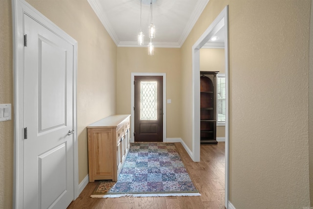 foyer entrance with ornamental molding and light hardwood / wood-style flooring