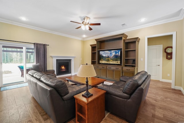 living room featuring crown molding, ceiling fan, and light hardwood / wood-style flooring