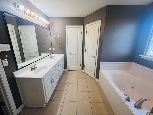 bathroom featuring a textured ceiling, a washtub, vanity, and tile patterned floors