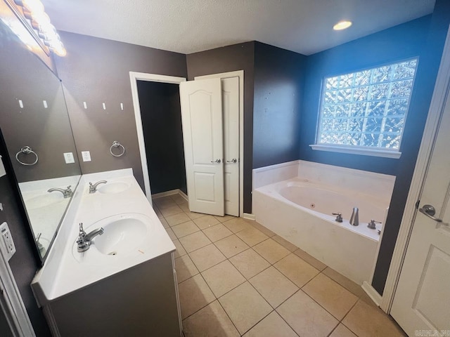 bathroom featuring tile patterned flooring, a bathtub, a textured ceiling, and vanity