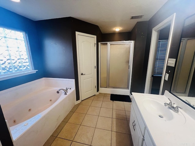 bathroom with a textured ceiling, tile patterned floors, independent shower and bath, and vanity