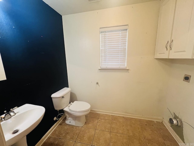 bathroom featuring toilet, tile patterned floors, and sink