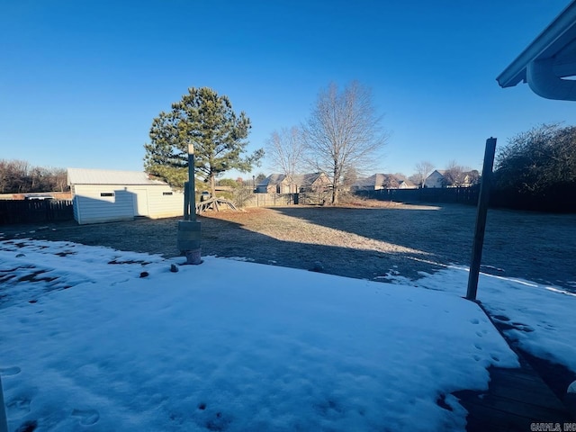 yard layered in snow featuring a storage unit