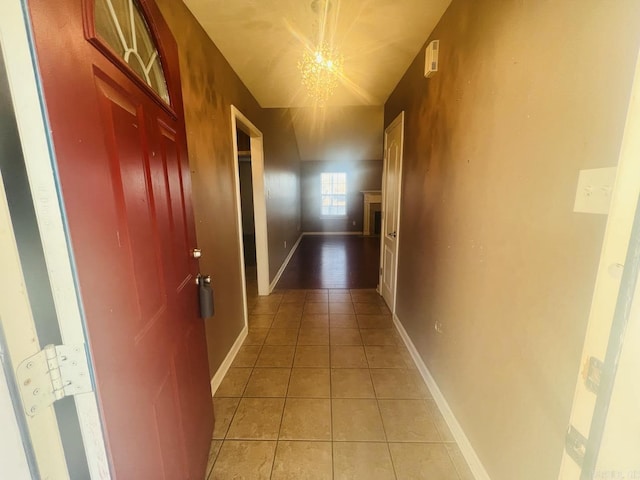 hallway with an inviting chandelier and light tile patterned floors