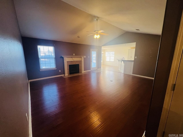 unfurnished living room featuring hardwood / wood-style flooring, ceiling fan, vaulted ceiling, and plenty of natural light