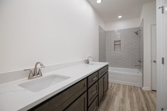 bathroom featuring tiled shower / bath, vanity, and hardwood / wood-style flooring