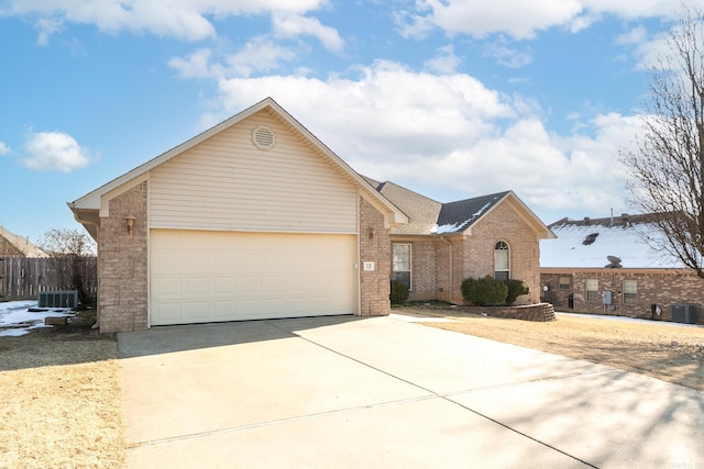 single story home with a garage and central AC unit