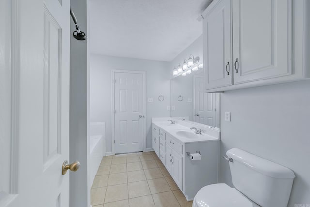 bathroom featuring tile patterned flooring, a tub, vanity, and toilet