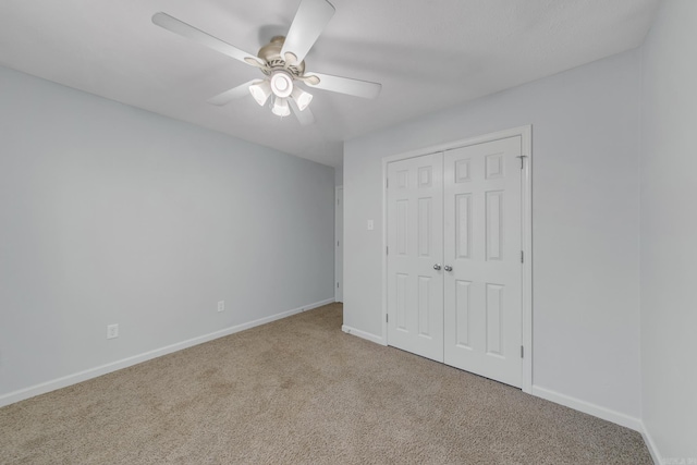 unfurnished bedroom with ceiling fan, light colored carpet, and a closet