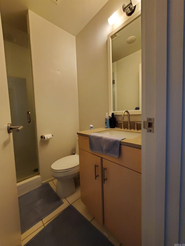 bathroom with toilet, a shower with door, vanity, and tile patterned flooring