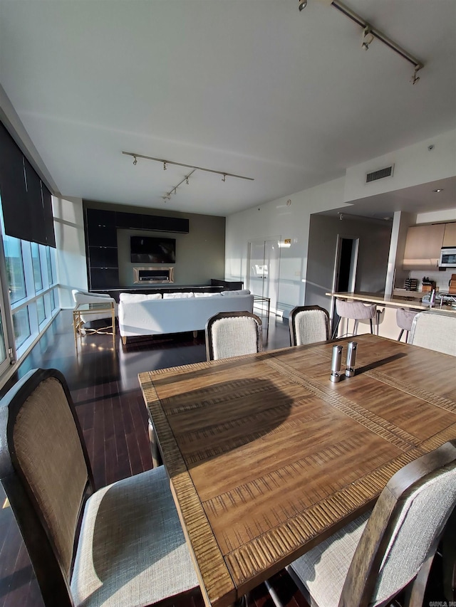 dining room featuring dark hardwood / wood-style flooring and rail lighting