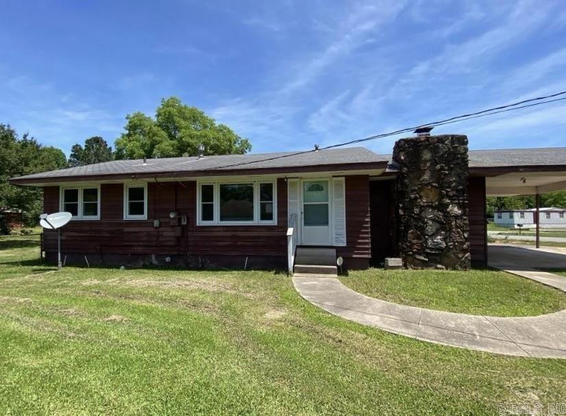 view of front of house with a carport and a front yard