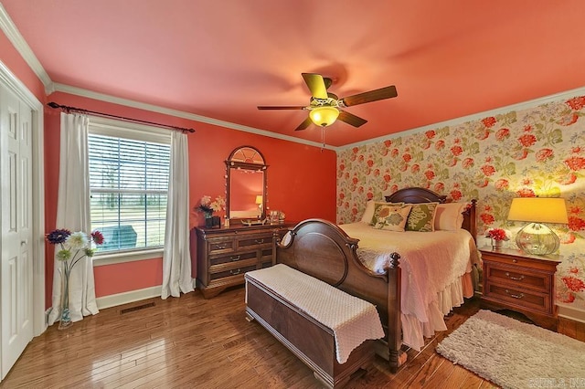 bedroom with a closet, ceiling fan, crown molding, and dark wood-type flooring