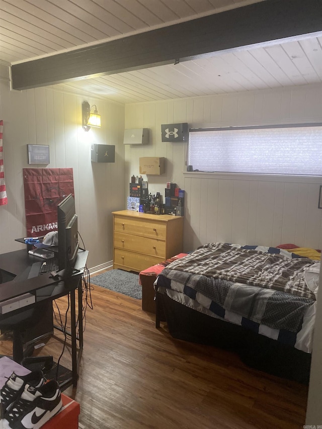 bedroom featuring hardwood / wood-style flooring and beam ceiling