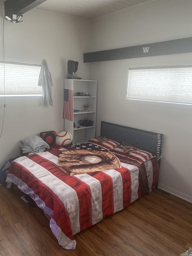 bedroom with dark hardwood / wood-style flooring and multiple windows