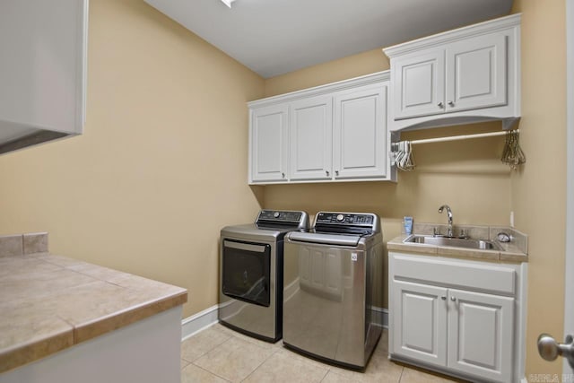 clothes washing area with sink, cabinets, washer and clothes dryer, and light tile patterned flooring