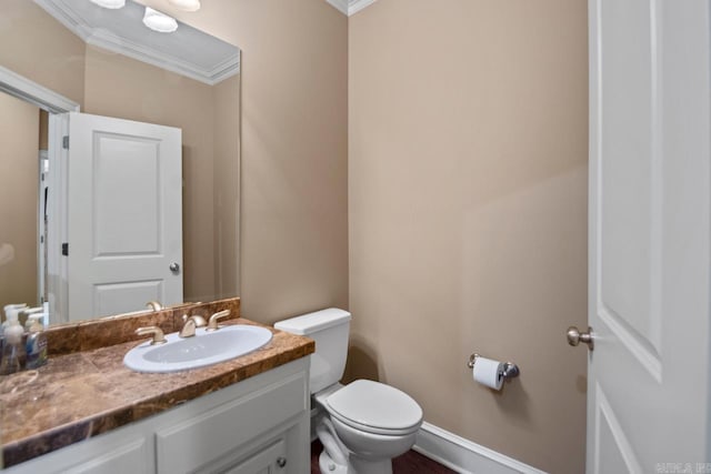 bathroom with toilet, vanity, and ornamental molding