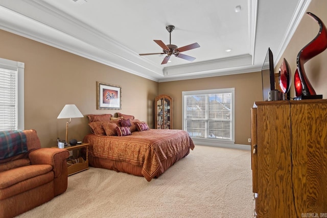 carpeted bedroom with ceiling fan, ornamental molding, and a tray ceiling