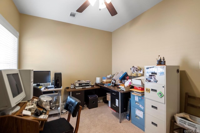 carpeted home office featuring ceiling fan