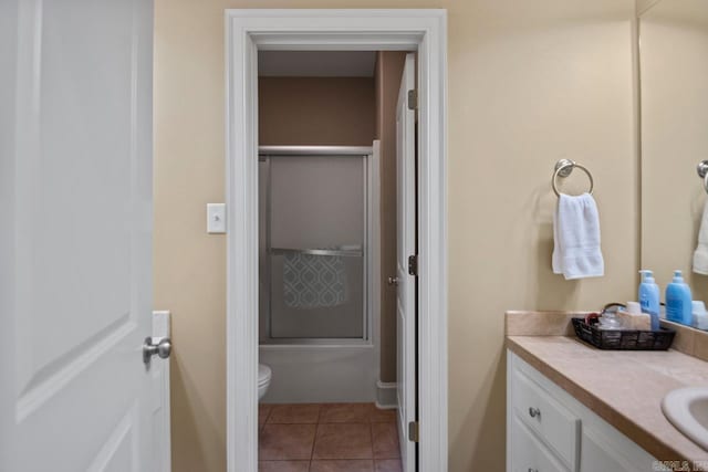 bathroom featuring vanity, tile patterned flooring, a shower with shower door, and toilet