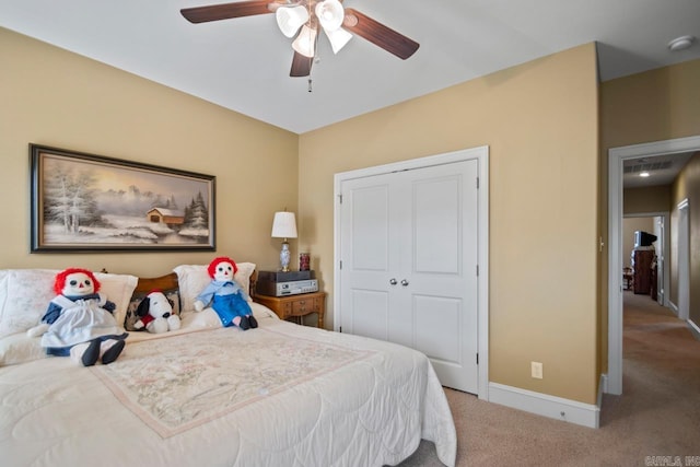 bedroom with a closet, ceiling fan, and light colored carpet