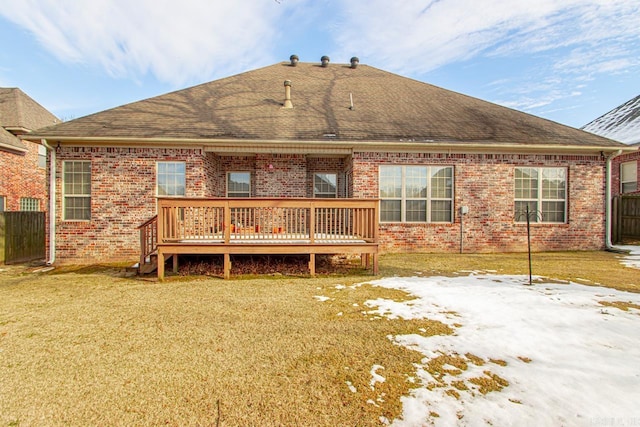 snow covered property with a yard and a deck