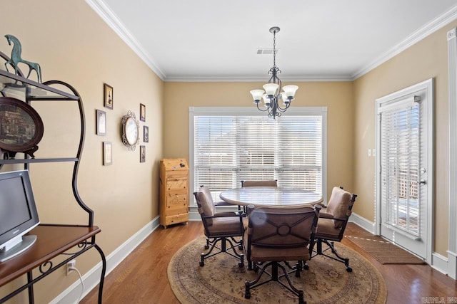 dining space featuring ornamental molding, a notable chandelier, and hardwood / wood-style flooring