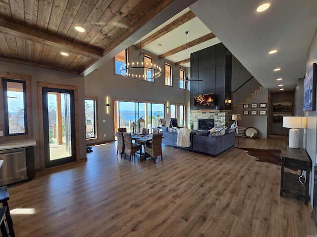 dining room featuring a fireplace, beamed ceiling, and dark hardwood / wood-style floors