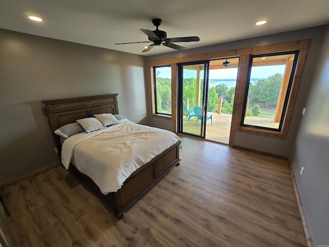 bedroom featuring dark hardwood / wood-style flooring, access to exterior, and ceiling fan