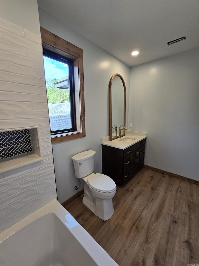 bathroom with toilet, vanity, and hardwood / wood-style floors