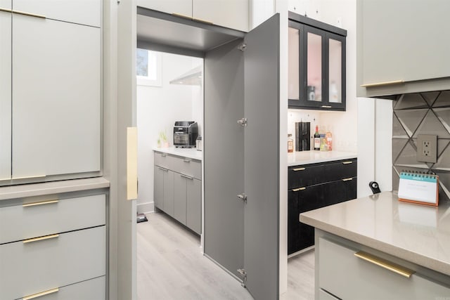 kitchen featuring light wood-type flooring and backsplash