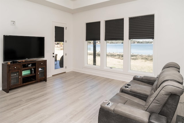 living room featuring light wood-type flooring and a water view