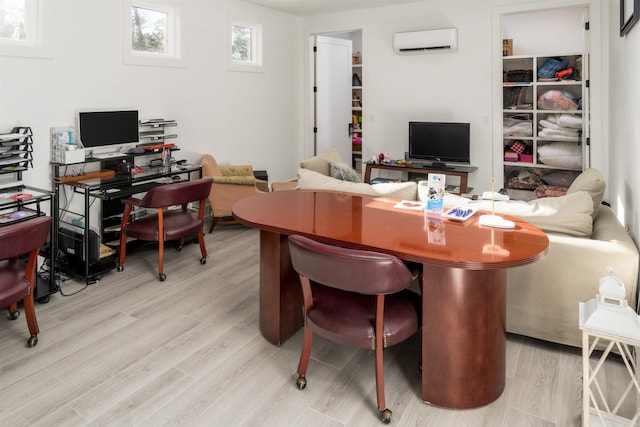 office space with light hardwood / wood-style floors and a wall mounted air conditioner