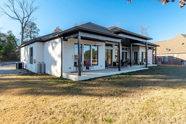 back of property featuring a patio, a yard, and central AC