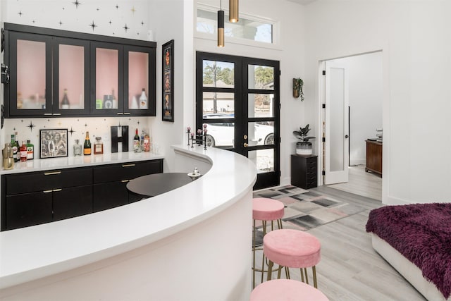 bar featuring french doors and light hardwood / wood-style flooring