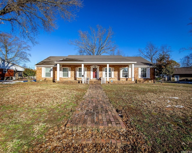 ranch-style house with a porch and a front lawn