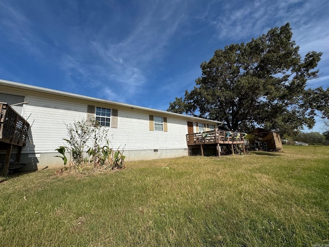 back of house featuring a deck and a lawn