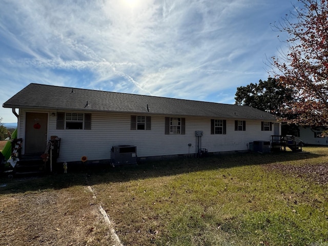 back of house featuring central AC and a yard